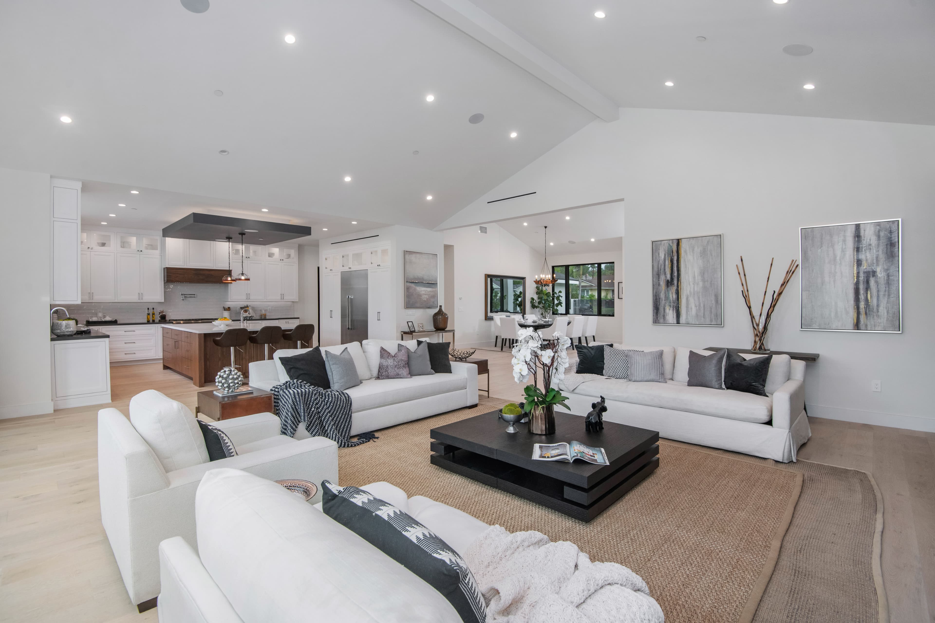 Open-plan living room with white sofas and natural light