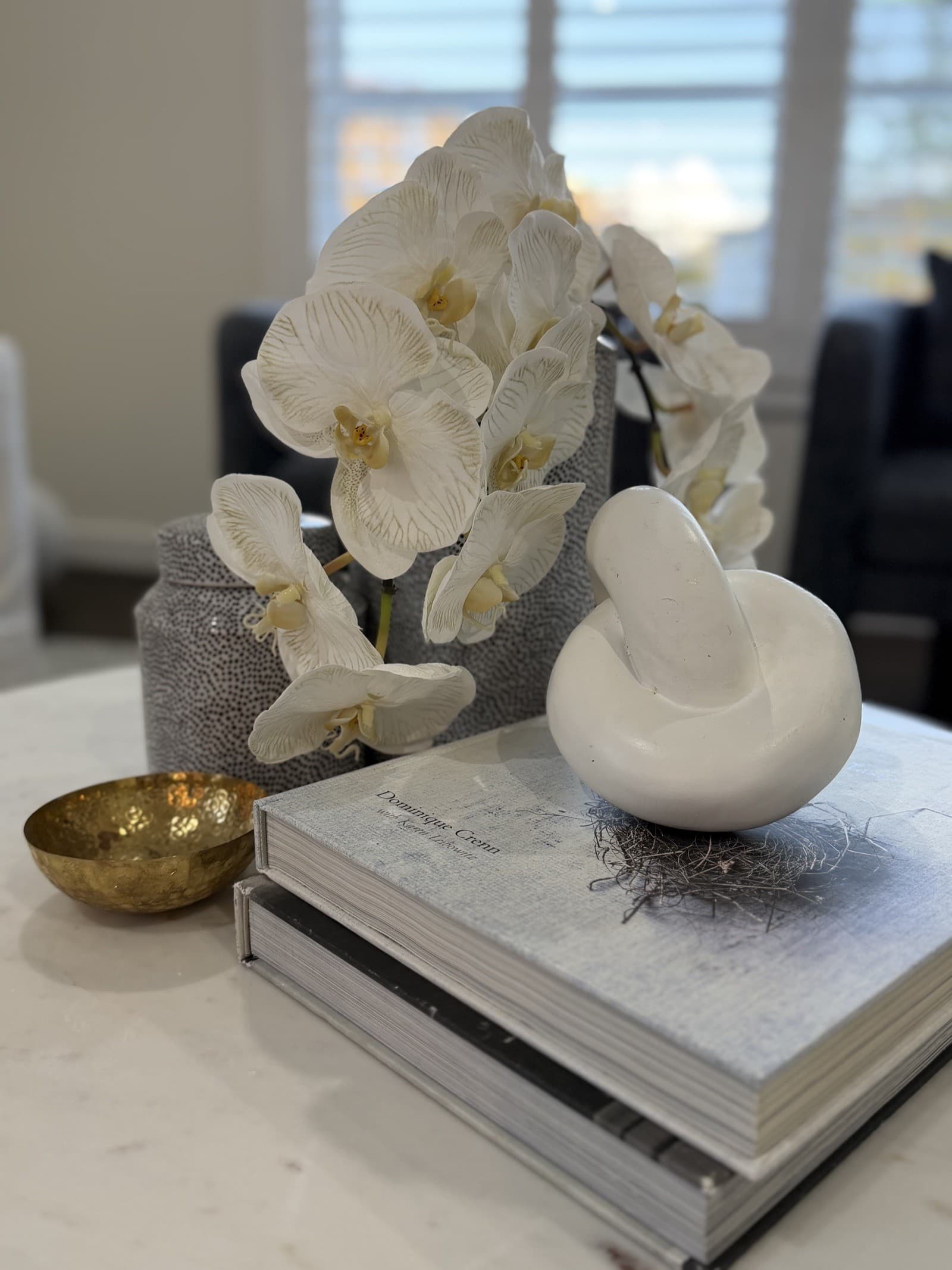 Coffee table styled with orchid and brass bowl — property styling North Shore Sydney