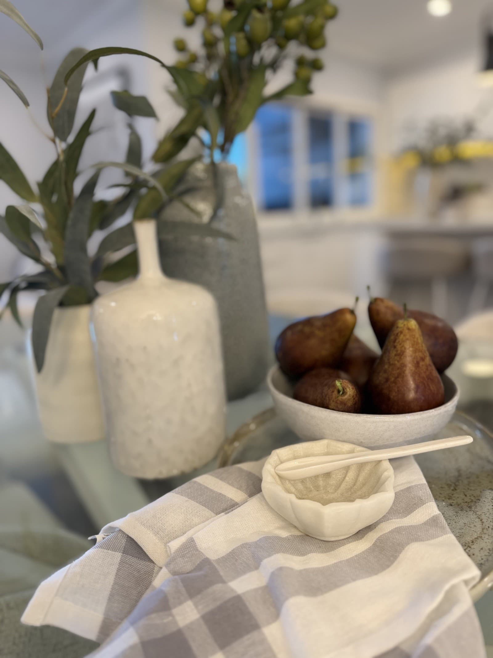 Dining tablescape detail with pears and ceramic vases — property styling North Shore Sydney
